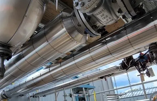 Industrial insulation being applied to piping and equipment